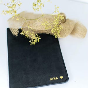 schwarze U-Hefthülle aus Leder mit Goldprägung