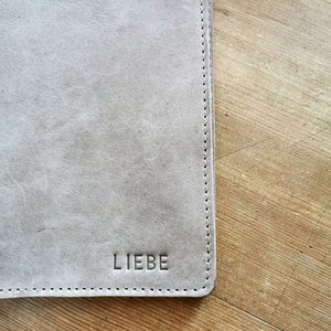 Uhefthülle in beige mit Prägung.