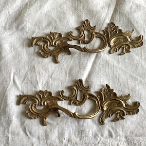Ensemble décoratif antique de deux poignées de meuble assorties en laiton doré, ancien magasin des années 1920, jamais utilisé, sur carte avec clous en laiton