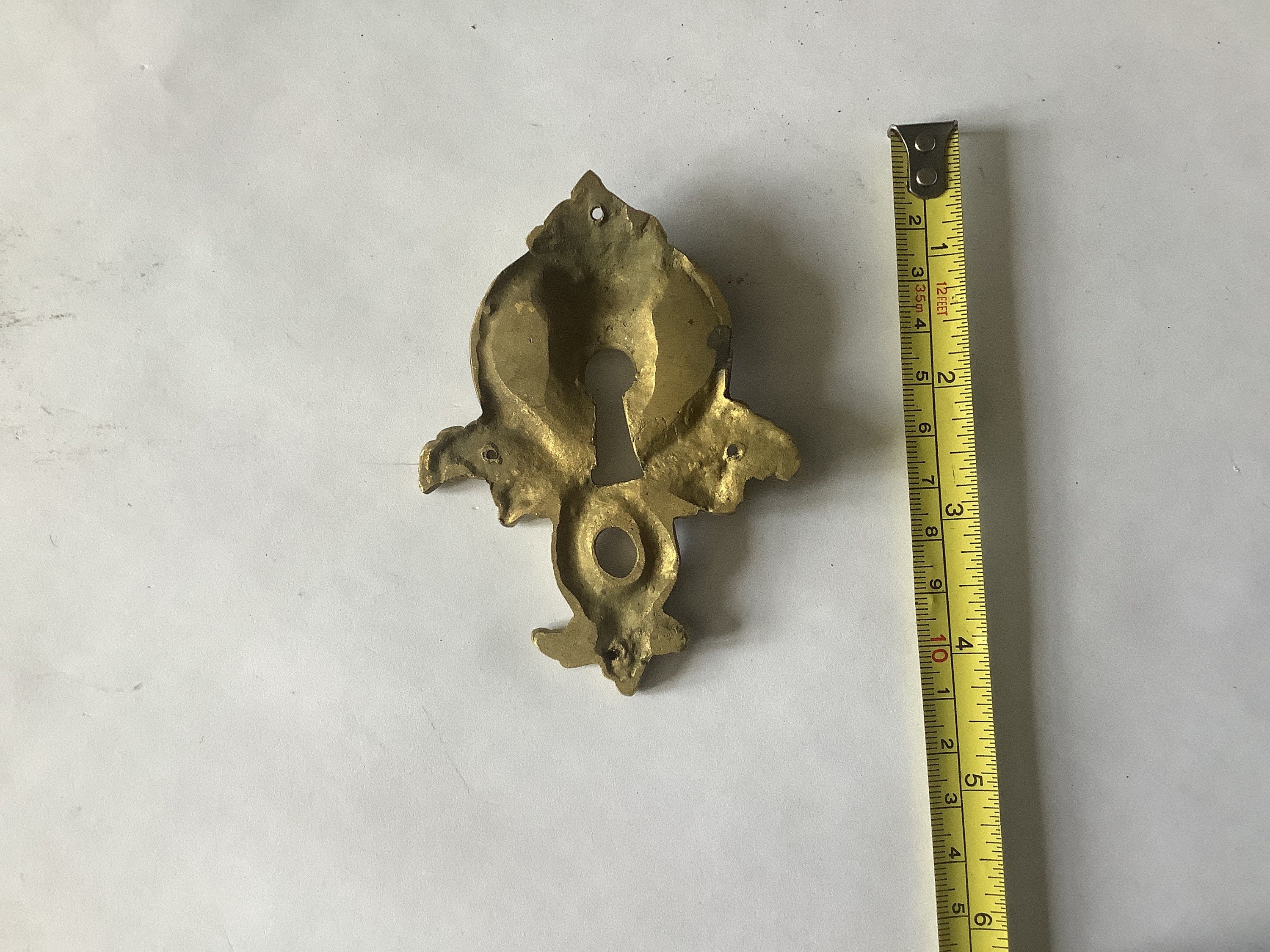 One Antique Brass Keyhole Cover Escutcheon made in France in the 1900s elegant and quality berries and leaves