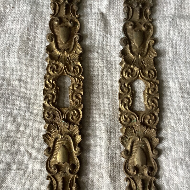A Set of Two Large Matching Antique Brass Keyhole Cover Made in France