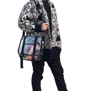 Puede incluir: Una mujer con un c&aacute;rdigan estampado en blanco y negro, pantalones negros y zapatillas de deporte de estampado de leopardo. Lleva un bolso bandolera de pl&aacute;stico transparente con correas negras.