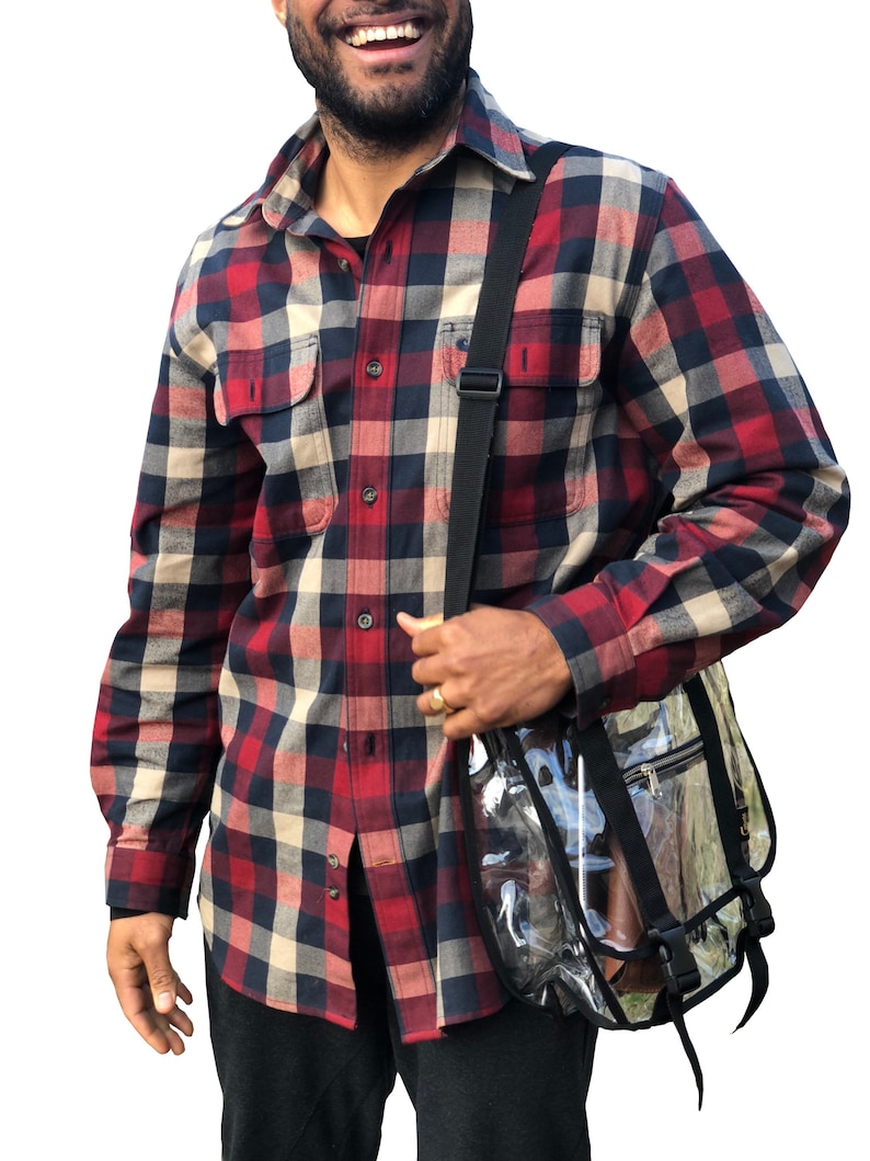 Puede incluir: Un hombre con una camisa de franela a cuadros rojos, negros y blancos con una bolsa de mensajero de pl&aacute;stico transparente con correas negras.