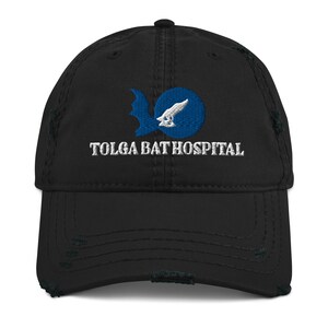 Peut inclure: Casquette de baseball noire usée avec un logo brodé blanc qui dit "Tolga Bat Hospital" et un graphique de chauve-souris bleu et blanc.