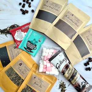May include: Assortment of tea and coffee bags in brown paper packaging with labels. The labels include the names of the different types of tea and coffee, such as "English Earl Grey", "Fruity Red", "Green Tea", "Decaf Roast Coffee", "The Breakfast Blend", and "Costa Rica". There are also two bags of Clipper brand organic tea, one with peppermint infusion and one with English breakfast tea. A bag of marshmallows and a Galaxy hot chocolate packet are also included.