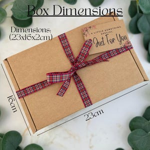 May include: A brown cardboard gift box tied with a red and green plaid ribbon. The box is labeled with the text "Box Dimensions" and "Just For You". The dimensions are 23cm x 16cm x 2cm, or approximately 9 x 6.3 x 0.8 inches.