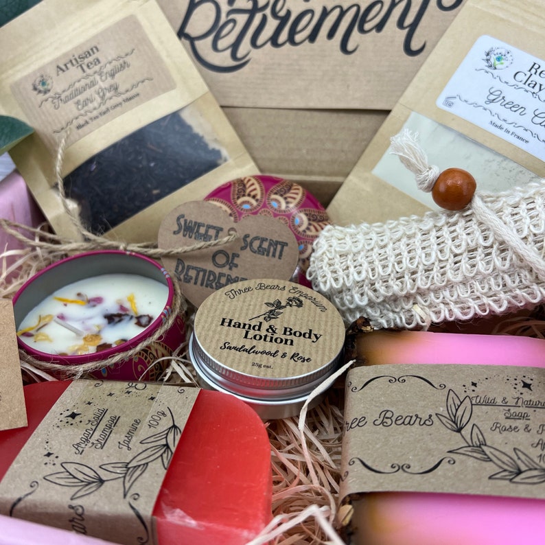 May include: A gift basket filled with various items for relaxation and self-care. The basket includes a candle, soap, lotion, tea, and a decorative heart with the text "Sweet Scent of Retirement".