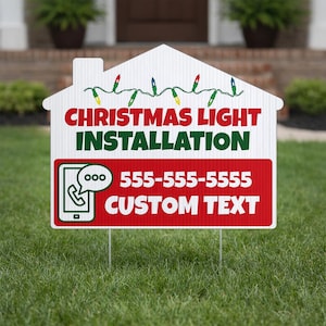 May include: A white, house-shaped sign with the words "CHRISTMAS LIGHT INSTALLATION" in red and green. A red rectangle at the bottom includes a phone icon and phone number. A string of Christmas lights is at the top.