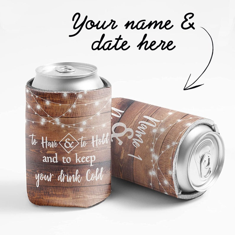 Op de afbeelding: Twee bruine en witte rustieke bruiloft-blikjeskoelers met lichtslingers en de tekst "To Have & to Hold and to keep your drink cold".