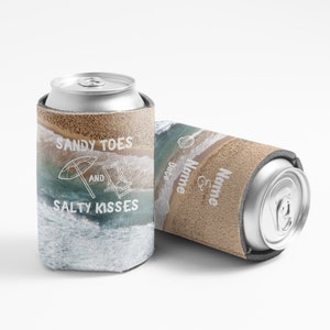 May include: Two brown and blue can coolers with a beach scene. One cooler has the text "Sandy Toes and Salty Kisses" and the other has the text "Name & Name Date".