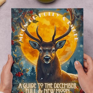 May include: A book cover featuring a majestic stag with large antlers set against a full moon. The title reads "Moon of Holly & Ember" and "A Guide to the December Full & New Moon". The artwork is surrounded by holly and berries, with a wintery forest scene.