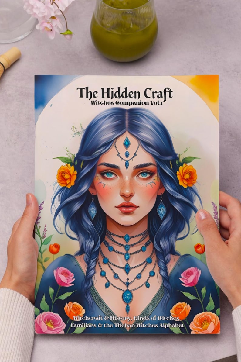 May include: A book cover titled "The Hidden Craft: Witches Companion Vol. 1" featuring a portrait of a woman with blue hair, adorned with floral and jewel accents. The cover art includes text about witchcraft and history.
