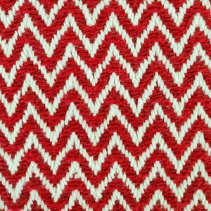 Puede incluir: Tejido tejido con patrón de chevron rojo y blanco. El tejido tiene una superficie texturizada, ligeramente peluda.
