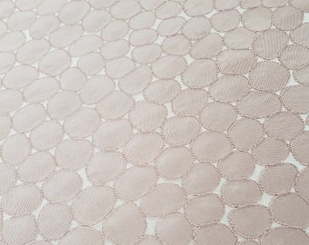 Tecido de círculos rosa blush sutil com contornos bordados deslumbrantes como roupas de cama, roupas, cortinas, talheres, etc.