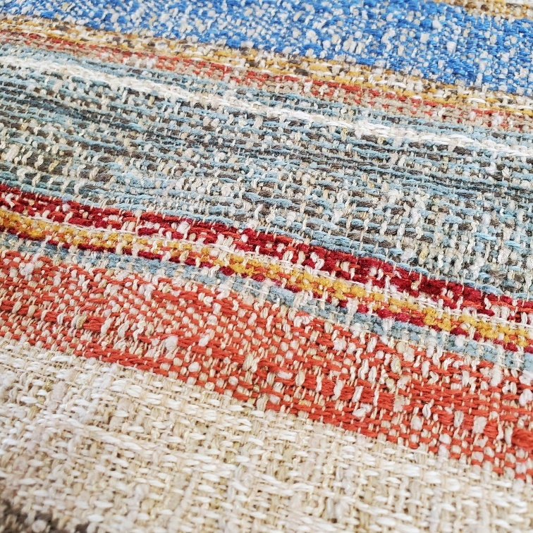 Rough spun organic looking multi-colored stripe woven in red, blue, green,& ivory, perfect for upholstery, tableware, bedding, drape, crafts