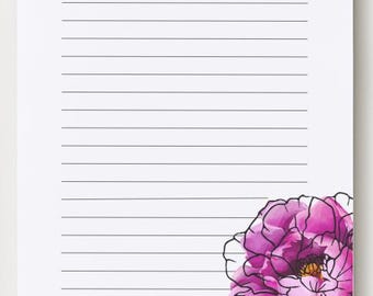 May include: A white notepad sheet featuring horizontal black lines for writing. The bottom right corner displays a large, vibrant pink and purple watercolor-style flower illustration. The text "The Notes We Take. The Life We Live." is printed in black at the bottom center.