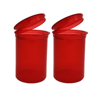 May include: Two red plastic pill bottles with lids open. The bottles are clear and have a textured surface.