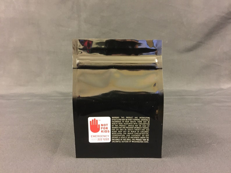 May include: Black mylar bag with a warning label that reads "Not for Kids" and includes an emergency contact number. The label has a red hand symbol and white text.