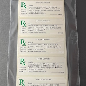 Può includere: Un sacchetto di plastica trasparente contenente diverse etichette bianche di cannabis medica. Ogni etichetta presenta un simbolo Rx verde, le parole "Cannabis Medica" e testo relativo al ceppo, alla conformità e alle avvertenze.