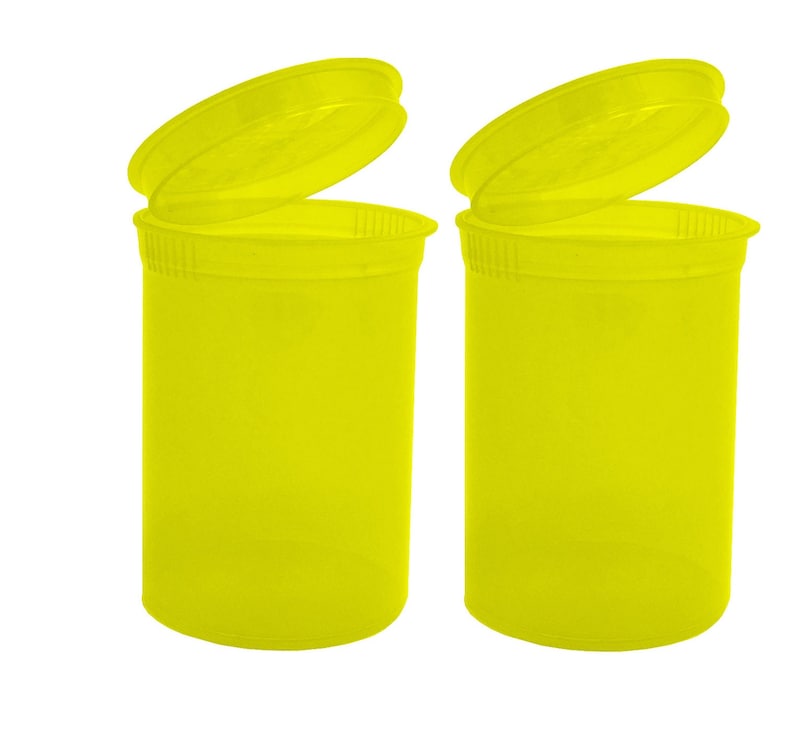 May include: Two bright yellow plastic pill containers with lids open. The containers are empty.