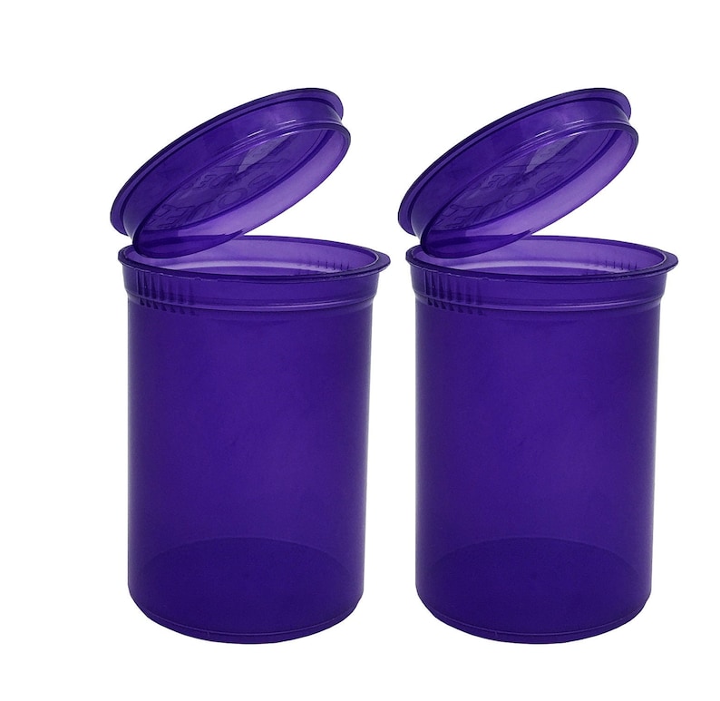 May include: Two purple plastic pill bottles with lids open. The bottles are opaque and have a smooth finish.