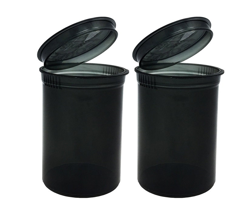 May include: Two black plastic pill containers with clear lids. The lids are open and the containers are empty.