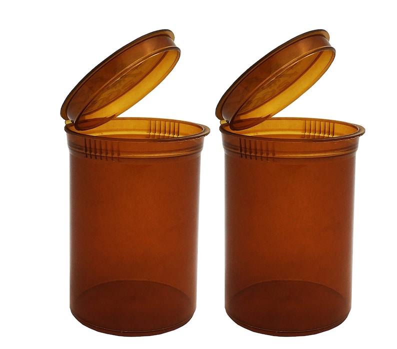 May include: Two amber-colored plastic pill bottles with child-resistant lids. The lids are open and the bottles are empty.