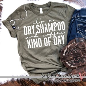May include: A green t-shirt with the text "it's a dry shampoo and coffee kind of day" in white lettering.