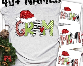 May include: A gray t-shirt with the word "GRAM" in colorful letters with a red heart and a Santa hat. The shirt is part of a set of 40+ names with different designs.