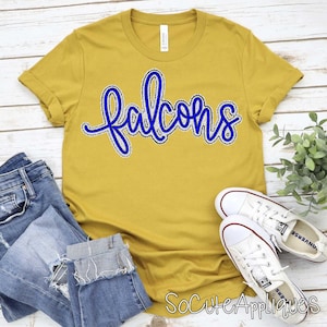 May include: Mustard yellow t-shirt with the word "Falcons" in blue script. The shirt is paired with blue jeans and white sneakers. The text "SoCuteAppliques" is at the bottom right.