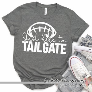 May include: Gray t-shirt with a white design of a football with the text "Just here to TAILGATE".
