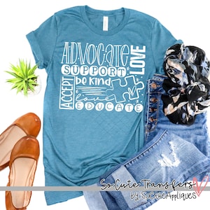 May include: A teal blue t-shirt with a white graphic design that says "Advocate, Support, Be Kind, Accept, Love, Educate" with a puzzle piece in the center. The graphic is in a white block font.
