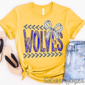 May include: Yellow t-shirt with the word "WOLVES" in blue, accented with black arrows and a dotted bow. The shirt is paired with blue jeans and sandals, suggesting casual wear. The text "SoCuteAppliques" is at the bottom.