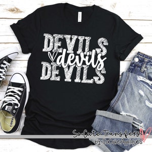 May include: Black t-shirt with the word "DEVILS" in white, stacked three times with a heart graphic. The shirt is paired with blue jeans and black Converse sneakers.