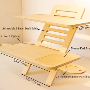 May include: A wooden adjustable standing desk with eight levels of height adjustment. The desk has two slots for electronics, a mouse pad area, and two hidden mug holders. The desk measures 25.6 inches wide, 22.44 inches tall, and 14.17 inches deep.