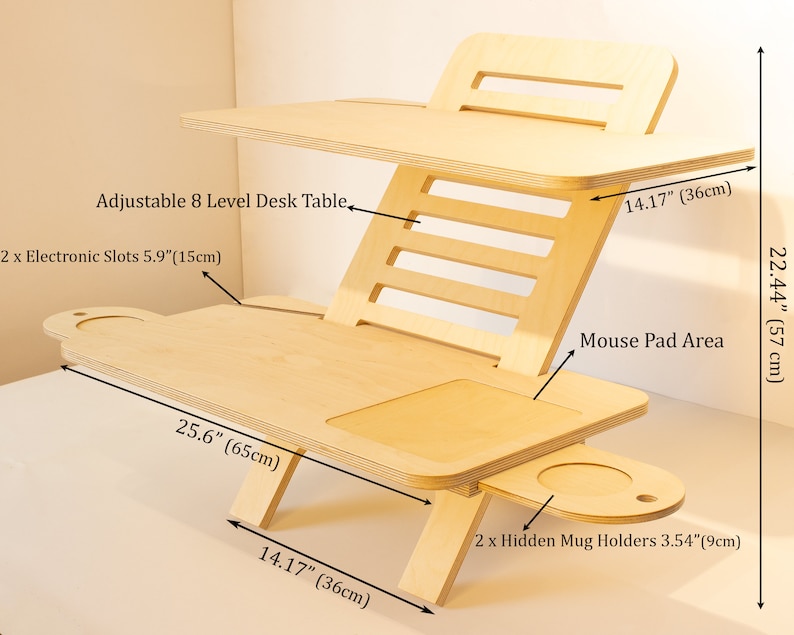 May include: A wooden adjustable standing desk with eight levels of height adjustment. The desk has two slots for electronics, a mouse pad area, and two hidden mug holders. The desk measures 25.6 inches wide, 22.44 inches tall, and 14.17 inches deep.