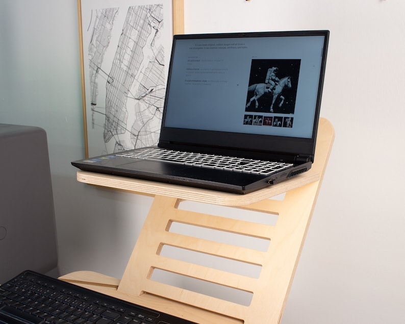 May include: A laptop computer with a black keyboard and a wooden laptop stand. The laptop is open and displaying a website with a picture of a person riding a horse.
