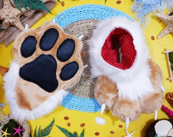 May include: A pair of furry brown and white paw-shaped slippers with black paw pads. The slippers have claws and are on a yellow background with various decorative items.