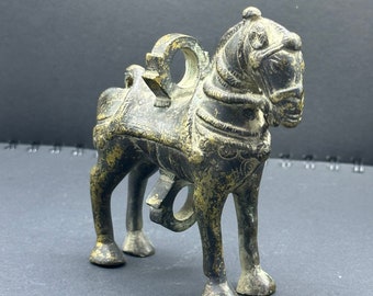 May include: A bronze horse sculpture with intricate details, possibly a lock or door handle. The horse is standing on all four legs and has a ring on its back.