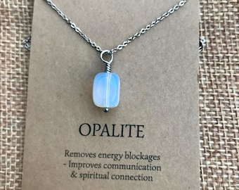 May include: A silver chain necklace with a white opalite pendant. The card reads "CALMER & KARMA Handmade in Cornwall U.K. OPALITE Removes energy blockages - Improves communication & spiritual connection"