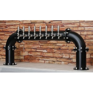 Könnte beinhalten: Schwarzer Bierzapfhahn aus Metall mit zehn Edelstahlhähnen. Der Turm ist an einer Backsteinwand montiert.