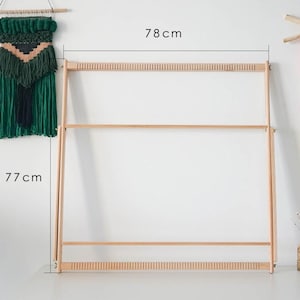 May include: A light-colored wooden weaving loom featuring a rectangular frame with notched top and bottom bars for thread alignment. The frame measures 78 cm in width and 77 cm in height, as indicated by the black dimension lines and text labels.