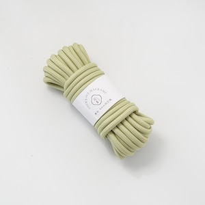 May include: A bundle of light green macrame cord, wrapped with a white label. The label features the text "SHEWEAVE MACRAME" and other text in a foreign language. The cord appears to be approximately 8mm in diameter.