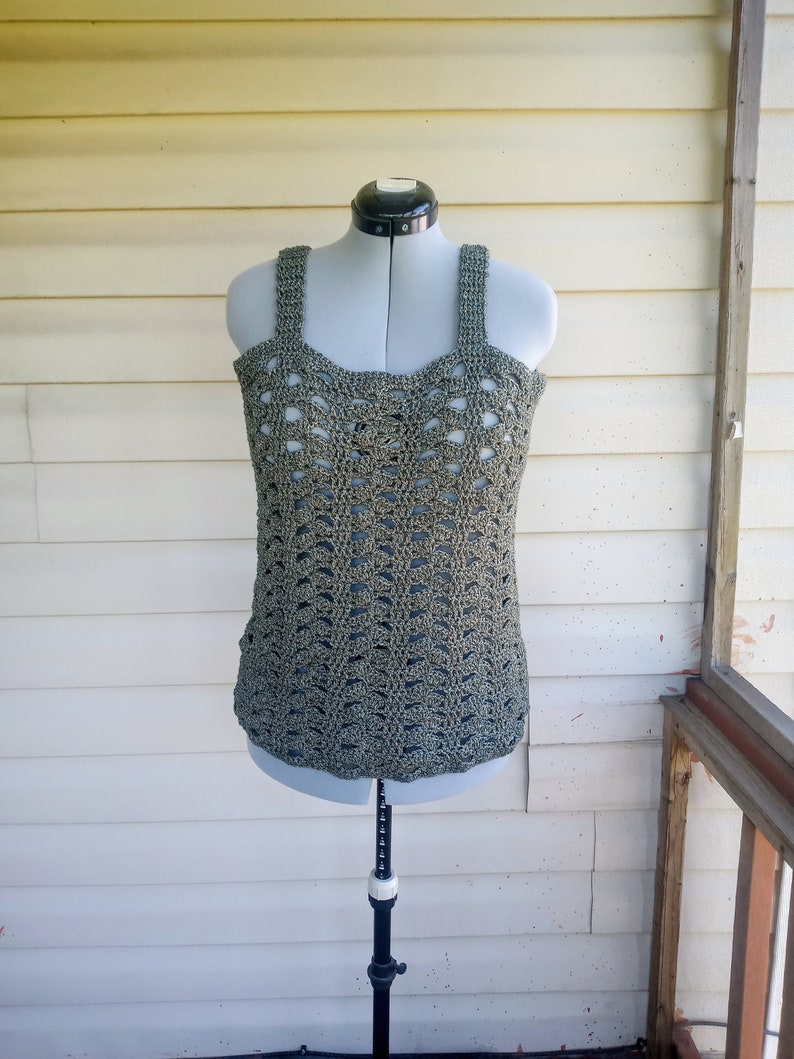 May include: A green crochet tank top with a delicate openwork pattern. The top is displayed on a mannequin.