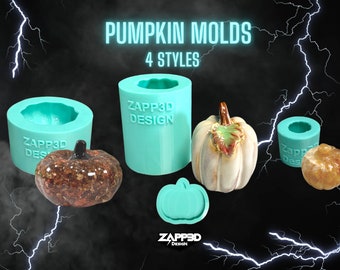 May include: Four silicone molds for making pumpkin-shaped crafts. The molds are turquoise blue and feature the text "ZAPP3D DESIGN". There are three finished pumpkins made with the molds, one is brown and glittery, one is white with a brown leaf, and one is orange.