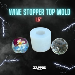 May include: A white silicone mold for making 1.5 inch wine bottle stoppers. The mold is shown with a finished resin stopper with dried flowers inside and a clear glass stopper.