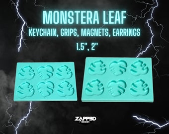 May include: Two turquoise silicone molds for making monstera leaf shapes. Each mold has six cavities, measuring 1.5 inches and 2 inches. The molds are on a black background with lightning bolts.