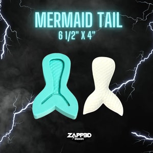 Może przedstawiać: Turkusowa silikonowa forma w kształcie ogona syreny z wzorem łusek. Forma ma wymiary 16,5 cm na 10 cm. Tekst "MERMAID TAIL" i "6 1/2" X 4" znajduje się nad formą.