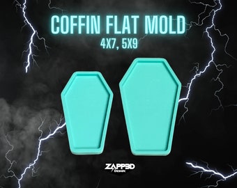 May include: Two turquoise blue coffin-shaped silicone molds for resin crafts. The larger mold is 5 inches by 9 inches and the smaller mold is 4 inches by 7 inches. The molds are on a black background with white lightning bolts.