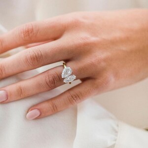 K&ouml;nnte beinhalten: Ein goldener Ring mit zwei birnenf&ouml;rmigen Diamanten, die nebeneinander gesetzt sind.